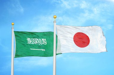 Suudi Arabistan ve Japonya bayrak direkleri ve mavi bulutlu arka planda iki bayrak
