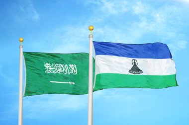 Suudi Arabistan ve Lesotho bayrak direkleri ve mavi bulutlu arka planda iki bayrak