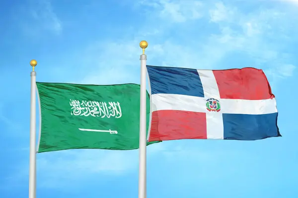 サウジアラビアとドミニカ共和国の旗竿と青空の背景に2つの旗 — ストック写真