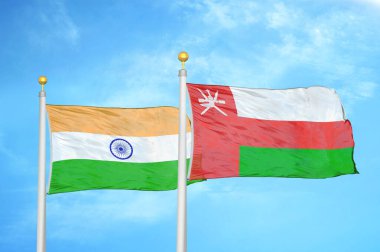 Hindistan ve Umman bayrak direkleri ve mavi bulutlu arka planda iki bayrak