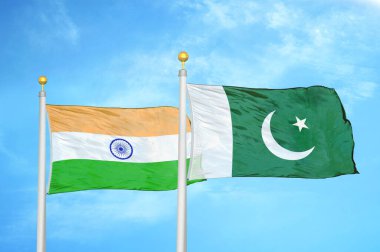 Hindistan ve Pakistan bayrak direkleri üzerinde iki bayrak ve mavi bulutlu arka plan