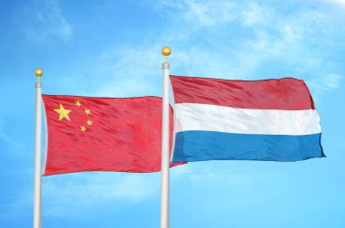 Çin ve Hollanda bayrak direkleri ve mavi bulutlu arka planda iki bayrak