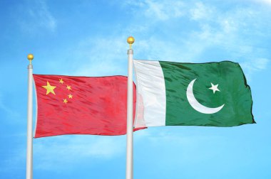 Çin ve Pakistan bayrak direkleri üzerinde iki bayrak ve mavi bulutlu arka plan