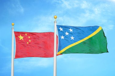 Çin ve Solomon Adaları bayrak direkleri ve mavi bulutlu arka planda iki bayrak