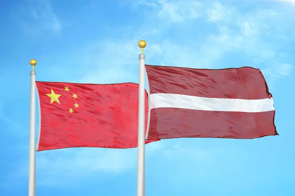 Chiny Łotwa Dwie Flagi Maszcie Flagowym Niebieskie Zachmurzone Tło Nieba — Zdjęcie stockowe