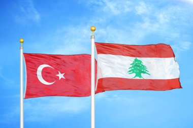 Türkiye ve Lübnan bayrak direkleri ve mavi bulutlu arka planda iki bayrak