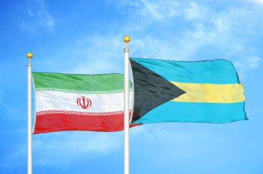 İran ve Bahamalar bayrak direkleri ve mavi bulutlu arka planda iki bayrak