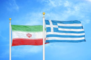 İran ve Yunanistan bayrak direkleri ve mavi bulutlu arka planda iki bayrak