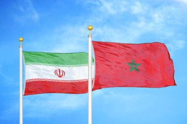 İran ve Fas bayrak direkleri ve mavi bulutlu arka planda iki bayrak