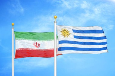 İran ve Uruguay bayrak direkleri ve mavi bulutlu arka planda iki bayrak