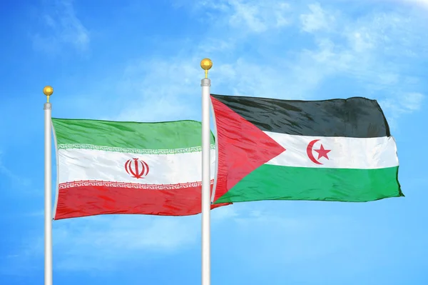 Iran and Western Sahara two flags on flagpoles and blue cloudy sky background