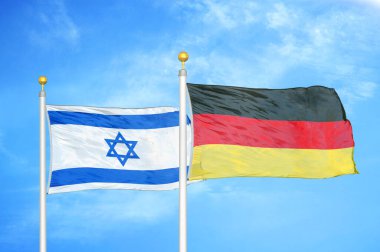 İsrail ve Almanya bayrak direkleri ve mavi bulutlu arka planda iki bayrak