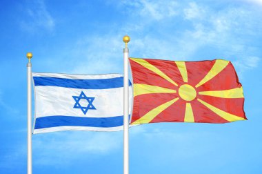 İsrail ve Kuzey Makedonya bayrak direkleri ve mavi bulutlu arka planda iki bayrak