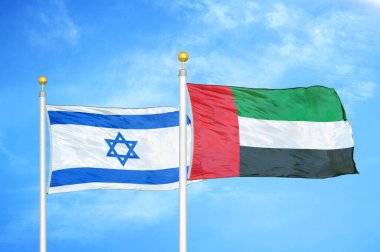 İsrail ve Birleşik Arap Emirlikleri bayrak direkleri ve mavi bulutlu arka planda iki bayrak