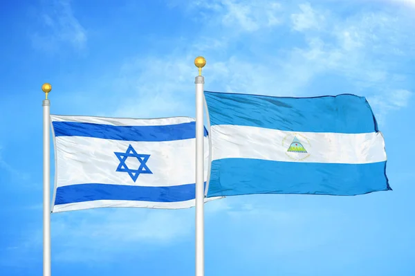 Israel Nicaragua Two Flags Flagpoles Blue Cloudy Sky Background — Stock Photo, Image