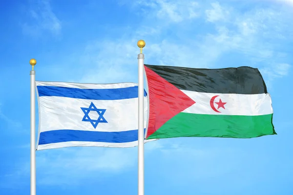 Israel and Western Sahara two flags on flagpoles and blue cloudy sky background