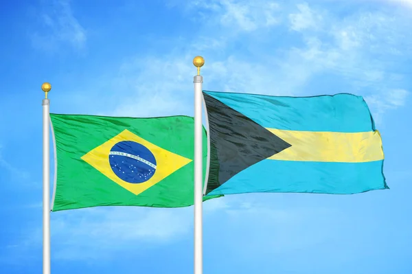 巴西和巴哈马旗杆上的两面旗帜和蓝云的天空背景 — 图库照片