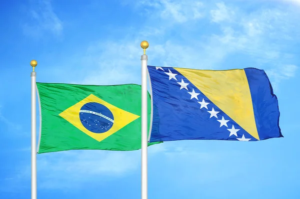 巴西和波斯尼亚和黑塞哥维那旗杆上的两面旗帜和蓝天背景 — 图库照片