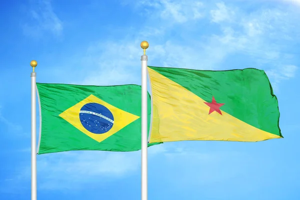 巴西和法属圭亚那旗杆上的两面旗帜和蓝天背景 — 图库照片
