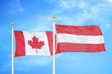 Kanada ve Avusturya bayrak direkleri ve mavi bulutlu arka planda iki bayrak