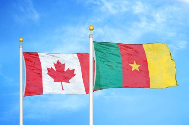 Kanada ve Kamerun bayrak direkleri ve mavi bulutlu arka planda iki bayrak