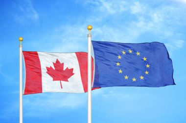 Kanada ve Avrupa Birliği bayrak direkleri ve mavi bulutlu arka planda iki bayrak