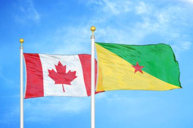 Kanada ve Fransız Guyanası bayrak direkleri ve mavi bulutlu arka planda iki bayrak