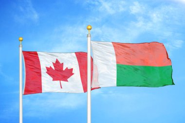 Kanada ve Madagaskar bayrak direkleri ve mavi bulutlu arka planda iki bayrak