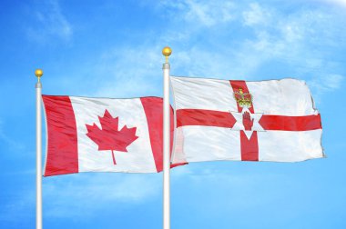 Kanada ve Kuzey İrlanda bayrak direkleri ve mavi bulutlu arka planda iki bayrak