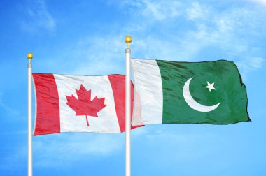Kanada ve Pakistan bayrak direkleri üzerinde iki bayrak ve mavi bulutlu arka plan