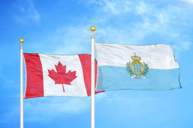 Kanada ve San Marino bayrak direkleri ve mavi bulutlu arka planda iki bayrak