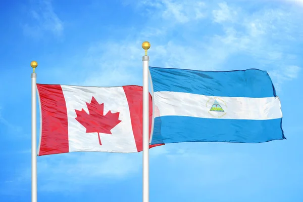 Canada Nicaragua Two Flags Flagpoles Blue Cloudy Sky Background — Stock Photo, Image