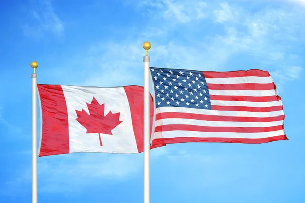 加拿大和美国旗杆上的两面国旗和蓝天背景 — 图库照片