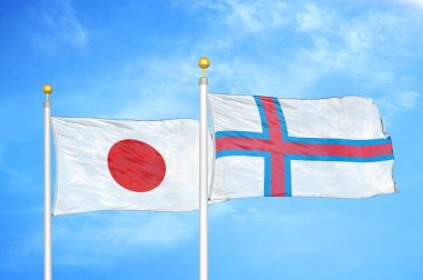 Japonya ve Faroe Adaları bayrak direkleri ve mavi bulutlu arka planda iki bayrak