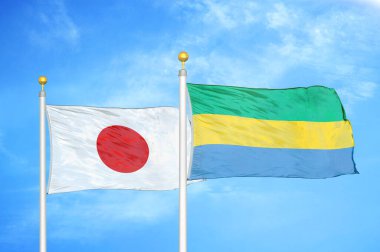 Japonya ve Gabon bayrak direkleri üzerinde iki bayrak ve mavi bulutlu arka plan