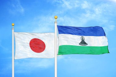 Japonya ve Lesotho bayrak direkleri ve mavi bulutlu arka planda iki bayrak
