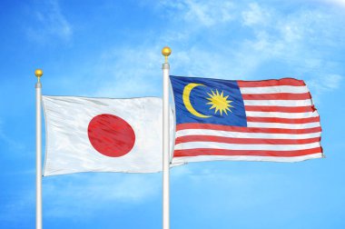 Japonya ve Malezya bayrak direkleri üzerinde iki bayrak ve mavi bulutlu arka plan
