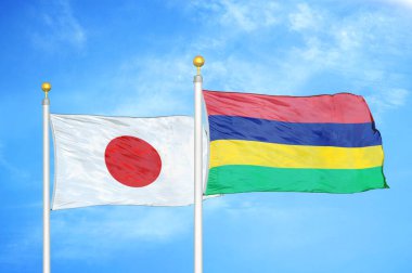 Japonya ve Mauritius bayrak direkleri ve mavi bulutlu arka planda iki bayrak