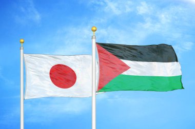 Japonya ve Filistin bayrak direkleri ve mavi bulutlu arka planda iki bayrak