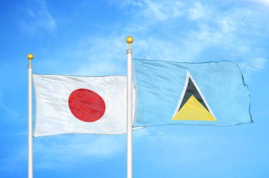 Japonya ve Saint Lucia bayrak direkleri ve mavi bulutlu arka planda iki bayrak