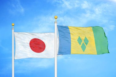 Japonya ve Saint Vincent ve Grenadines bayrak direkleri üzerinde iki bayrak ve mavi bulutlu gökyüzü arka planı