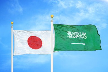 Japonya ve Suudi Arabistan bayrak direkleri ve mavi bulutlu arka planda iki bayrak