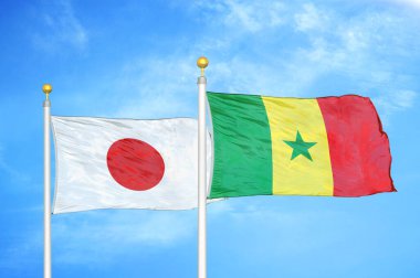Japonya ve Senegal bayrak direkleri ve mavi bulutlu arka planda iki bayrak
