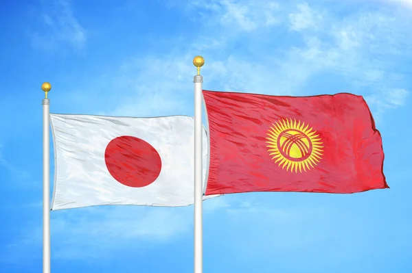Japão Quirguistão Duas Bandeiras Postes Bandeira Azul Céu Nublado Fundo — Fotografia de Stock