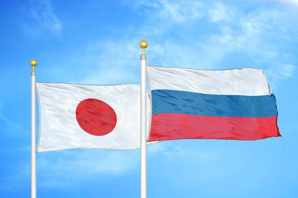 日本和俄罗斯旗杆上的两面旗帜和蓝天背景 — 图库照片