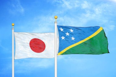 Japonya ve Solomon Adaları bayrak direkleri ve mavi bulutlu arka planda iki bayrak