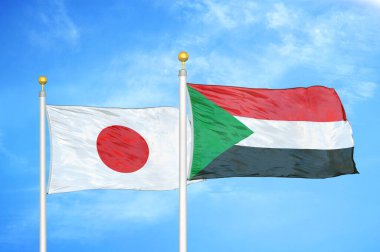 Japonya ve Sudan bayrak direkleri üzerinde iki bayrak ve mavi bulutlu arka plan