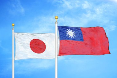 Japonya ve Tayvan bayrak direkleri ve mavi bulutlu arka planda iki bayrak