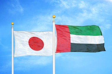 Japonya ve Birleşik Arap Emirlikleri bayrak direkleri ve mavi bulutlu arka planda iki bayrak