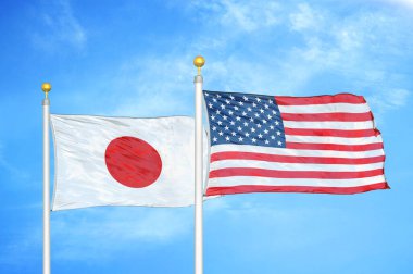 Japonya ve ABD bayrak direkleri ve mavi bulutlu arka planda iki bayrak